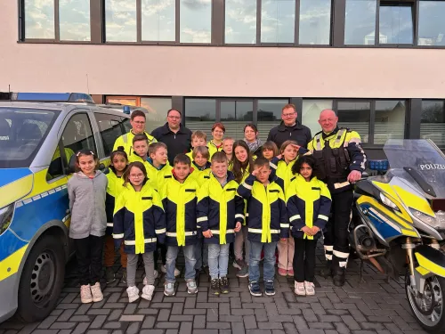 Kinderfeuerwehr zu Besuch bei der Polizei mit Einsatzfahrzeug und Motorrad