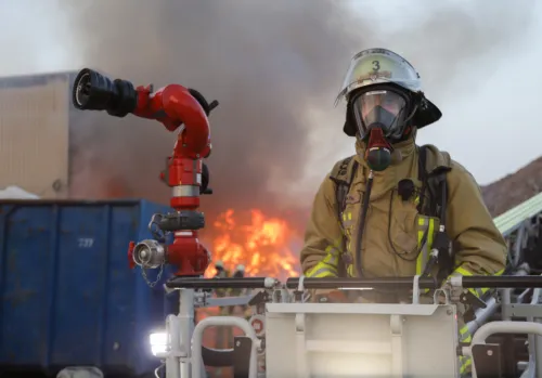 Feuerwehrmann mit Drehleiter beim Löschen eines Großbrandes