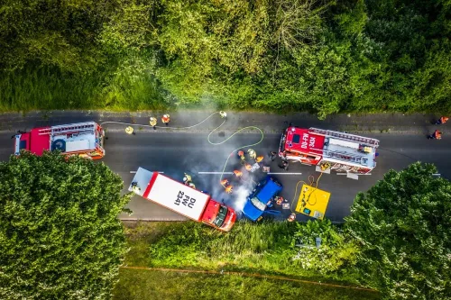 Feuerwehreinsatz von oben: mehrere Löschfahrzeuge und Einsatzkräfte an der Unfallstelle