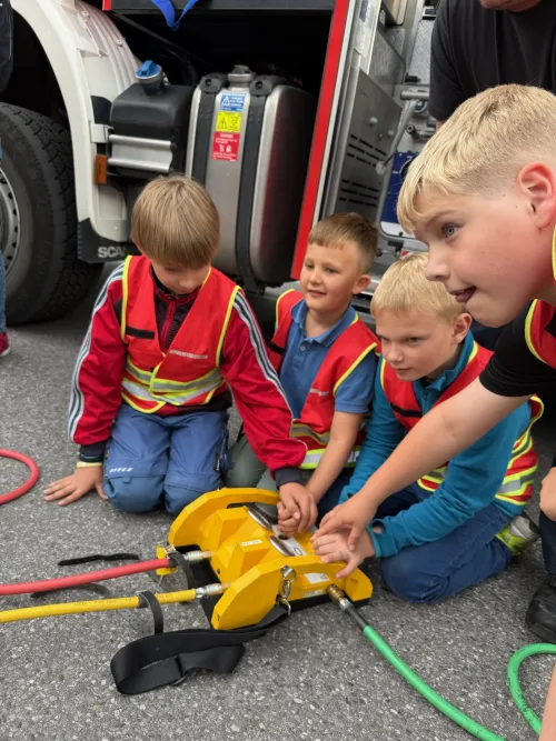 Kinder probieren Feuerwehr-Hebekissen unter Anleitung aus