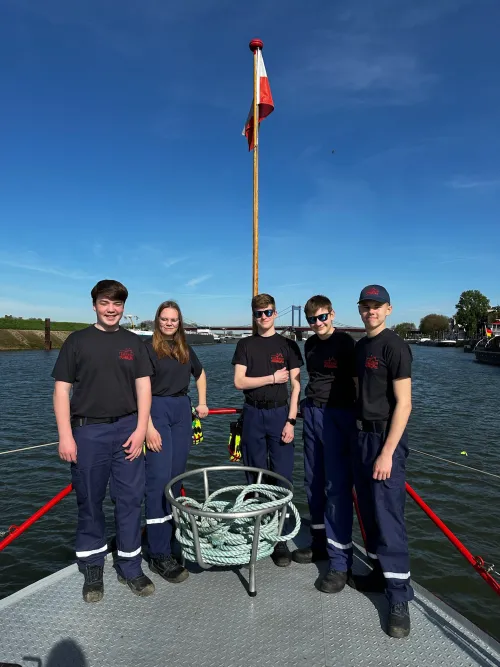 Mitglieder der Jugendfeuerwehr auf einem Feuerwehrboot auf dem Wasser