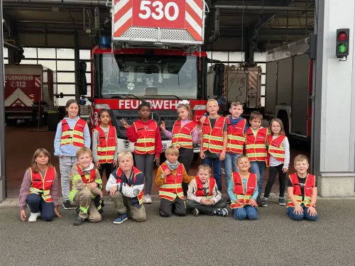 Kinderfeuerwehr posiert vor einer großen Drehleiter der Feuerwehr Duisburg